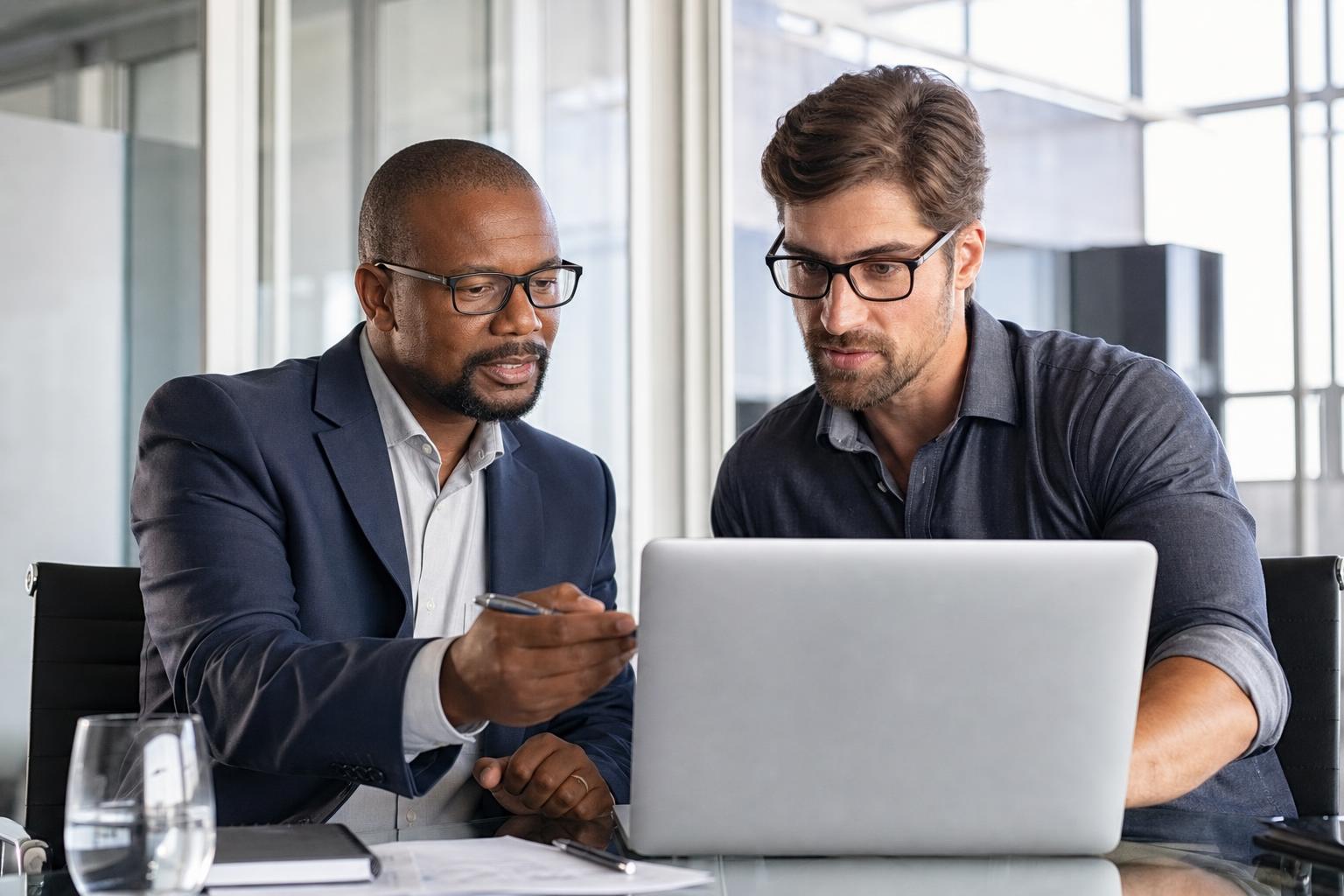 Dos profesionales TI revisando una plataforma en un notebook